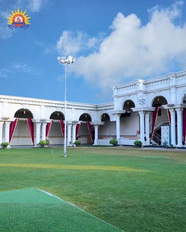 White arched FRP venue building with lawn and red drapes
