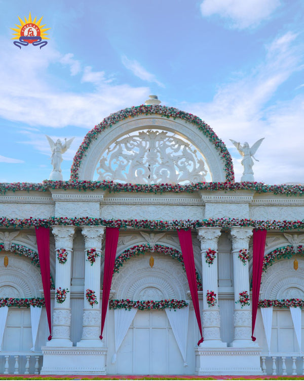 Arched wedding entrance with carved medallion and floral garlands