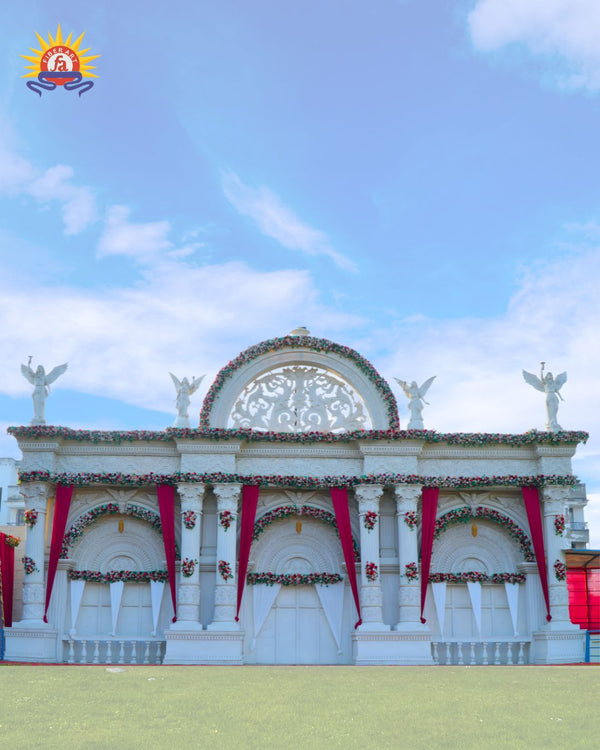 White GRC wedding venue entrance with red drapes and floral decor