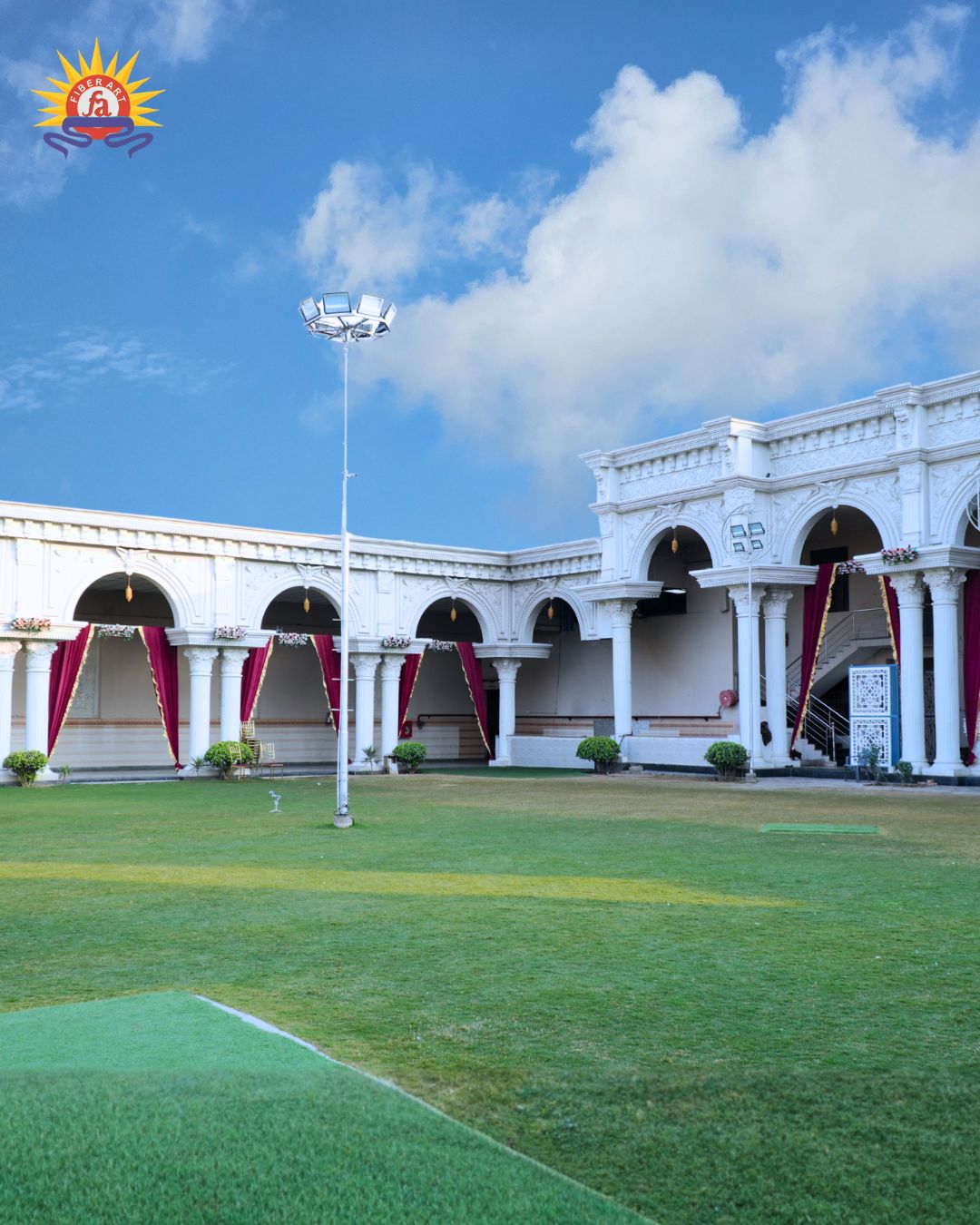 White arched wedding venue building with lawn